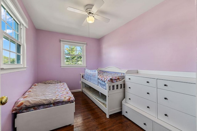bedroom with baseboards, a ceiling fan, and dark wood finished floors