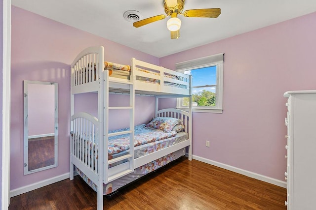 bedroom with baseboards, a ceiling fan, wood finished floors, and visible vents