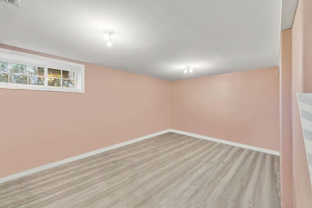 below grade area featuring light wood-type flooring, baseboards, and visible vents