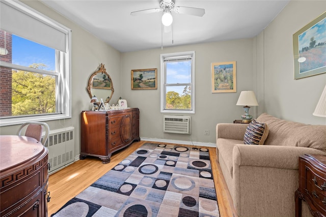 6300 Riverdale Ave Unit 5E, Bronx, NY 10471 - sitting room featuring radiator, baseboards, light wood-type flooring, a wall unit AC, and a ceiling fan