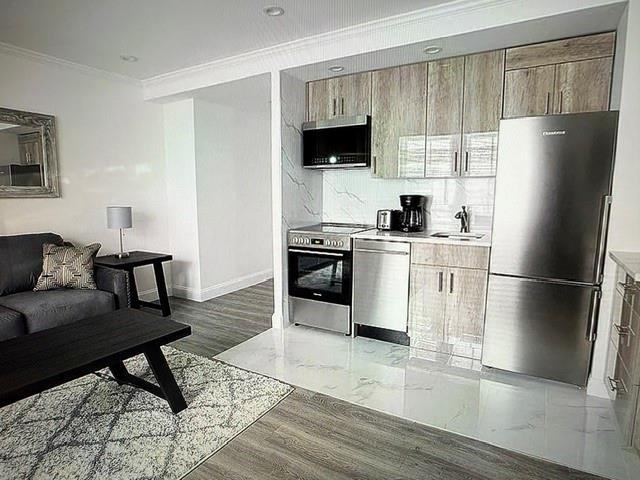 150 W 51 Unit 1032, New York Manhattan, NY 10019 - kitchen featuring appliances with stainless steel finishes, crown molding, a sink, tasteful backsplash, and light countertops