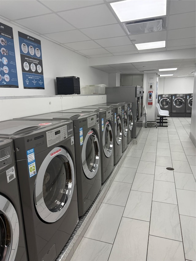 150 W 51 Unit 1032, New York Manhattan, NY 10019 - communal laundry room with washer and clothes dryer and light tile patterned floors