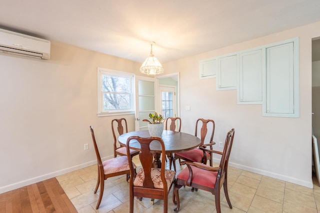 dining area with baseboards, a wall mounted air conditioner, and a chandelier