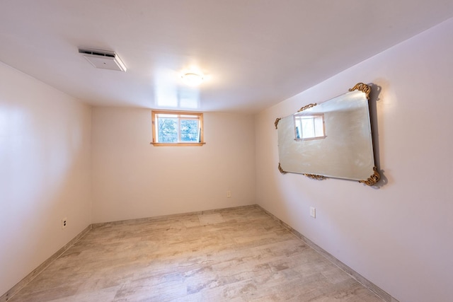basement featuring light wood finished floors and visible vents