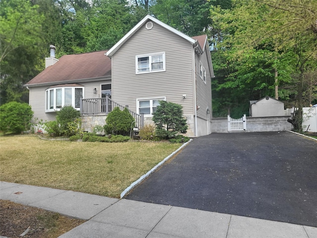 142 Pembrook Dr, Yonkers, NY 10710 - tri-level home featuring a chimney, a front yard, an outdoor structure, and aphalt driveway
