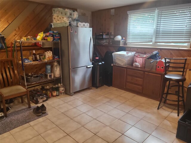 142 Pembrook Dr, Yonkers, NY 10710 - kitchen featuring freestanding refrigerator, wood walls, and light tile patterned floors