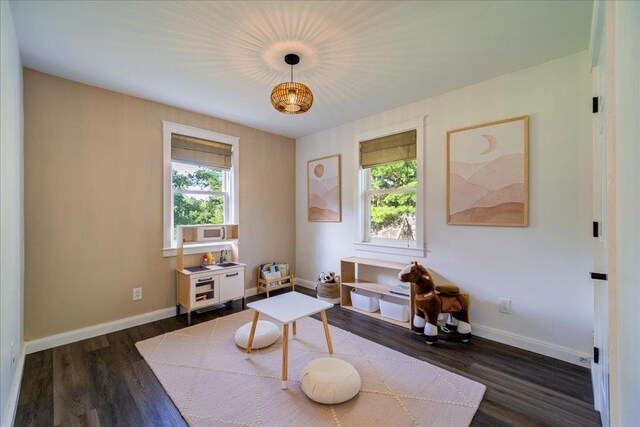 sitting room featuring baseboards and dark wood-style flooring