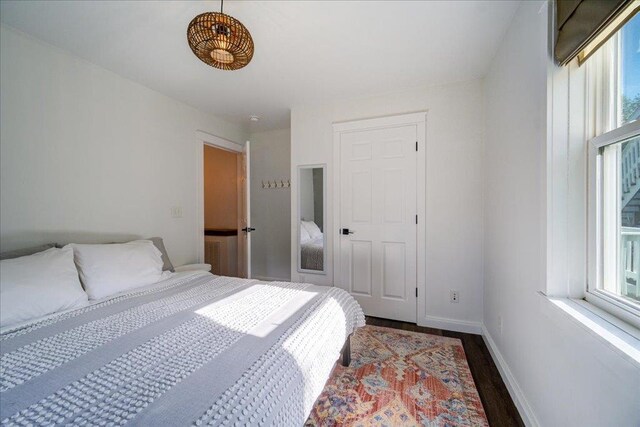 bedroom featuring baseboards and dark wood finished floors