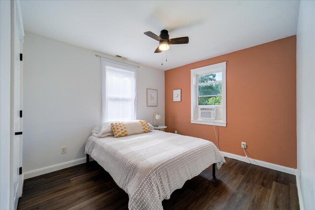 bedroom featuring visible vents, baseboards, ceiling fan, and wood finished floors