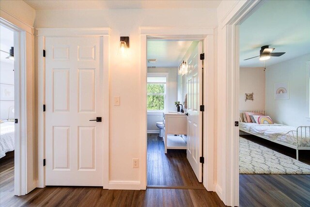 corridor featuring baseboards and dark wood-style floors