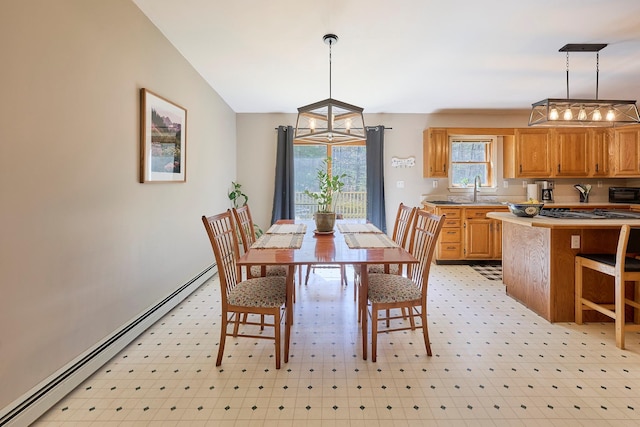 dining area with a chandelier, a baseboard heating unit, and lofted ceiling