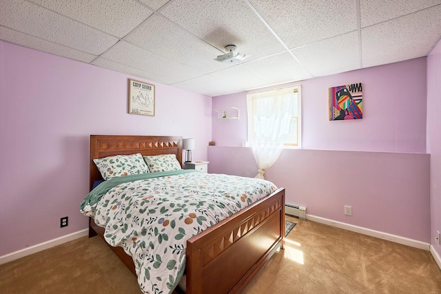 carpeted bedroom featuring a paneled ceiling, baseboards, and baseboard heating