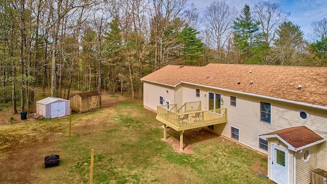 back of property with a yard, a shed, an outbuilding, and a deck