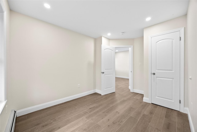 61-12 160th St, Fresh Meadows, NY 11365 - below grade area featuring light wood-style floors, a baseboard radiator, recessed lighting, and baseboards