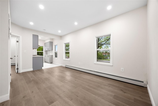 61-12 160th St, Fresh Meadows, NY 11365 - unfurnished living room featuring a baseboard heating unit, light wood finished floors, plenty of natural light, and recessed lighting