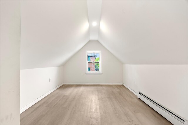 61-12 160th St, Fresh Meadows, NY 11365 - additional living space featuring a baseboard radiator, vaulted ceiling, light wood-style floors, and baseboards