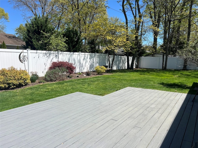 wooden terrace with a fenced backyard and a yard