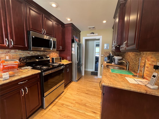 kitchen featuring visible vents, a sink, decorative backsplash, and appliances with stainless steel finishes