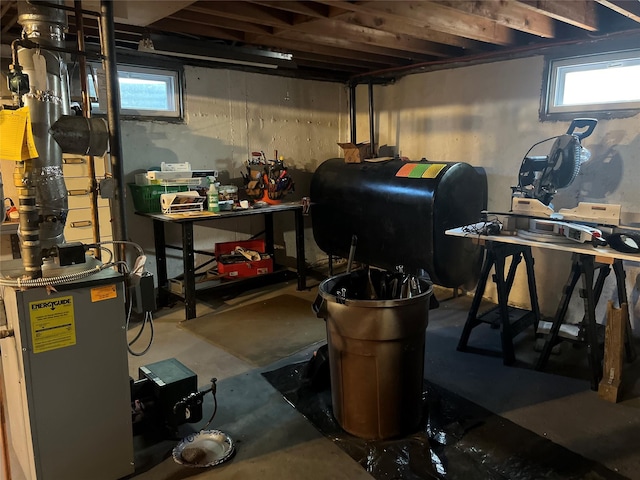 basement with heating fuel, a healthy amount of sunlight, and a workshop area