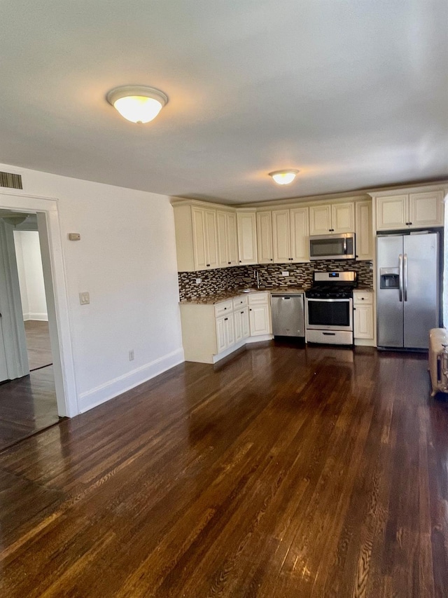 58 7th St, Valley Stream, NY 11581 - kitchen featuring appliances with stainless steel finishes, cream cabinets, decorative backsplash, and dark wood finished floors