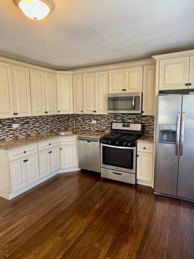 58 7th St, Valley Stream, NY 11581 - kitchen with stainless steel appliances, dark wood-style floors, decorative backsplash, and cream cabinetry