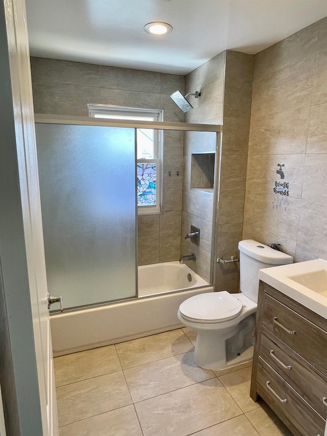 58 7th St, Valley Stream, NY 11581 - bathroom featuring vanity, bath / shower combo with glass door, tile patterned floors, and tile walls