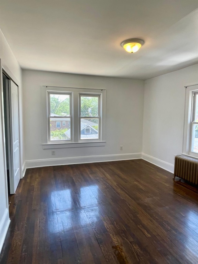 58 7th St, Valley Stream, NY 11581 - unfurnished room with dark wood-style flooring and radiator