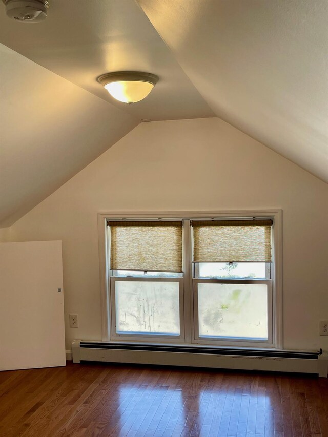 58 7th St, Valley Stream, NY 11581 - bonus room with a baseboard radiator, dark wood finished floors, healthy amount of natural light, and vaulted ceiling