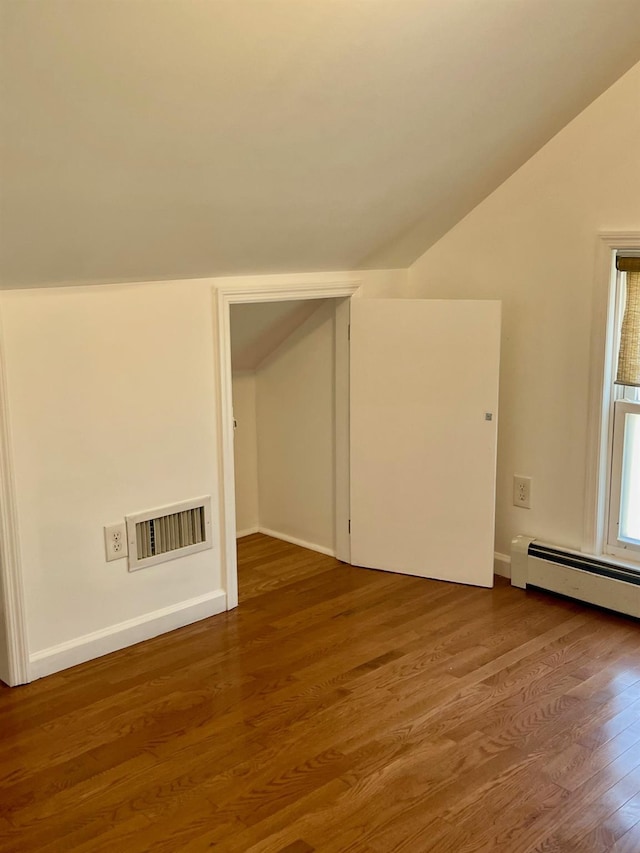 58 7th St, Valley Stream, NY 11581 - bonus room with wood finished floors, vaulted ceiling, and a baseboard heating unit