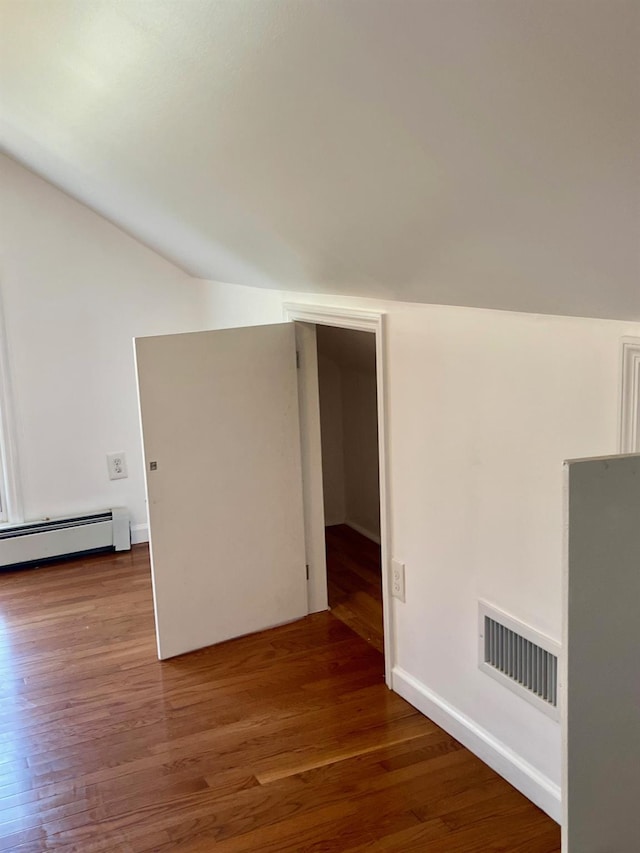 58 7th St, Valley Stream, NY 11581 - additional living space with vaulted ceiling, wood finished floors, and a baseboard heating unit
