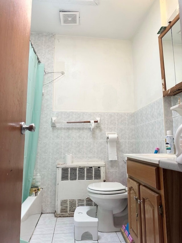 full bath with toilet, tile patterned floors, radiator, tile walls, and visible vents