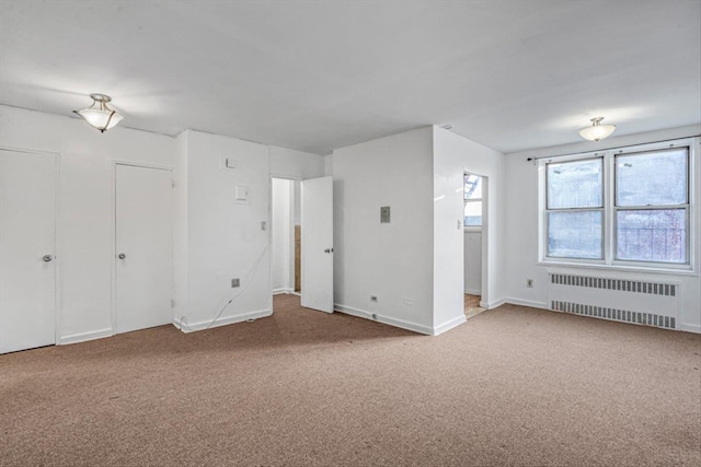 interior space with carpet floors, baseboards, and radiator heating unit