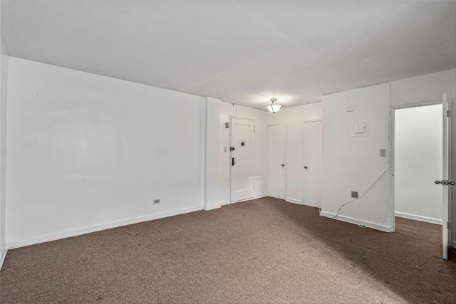 empty room featuring baseboards and carpet