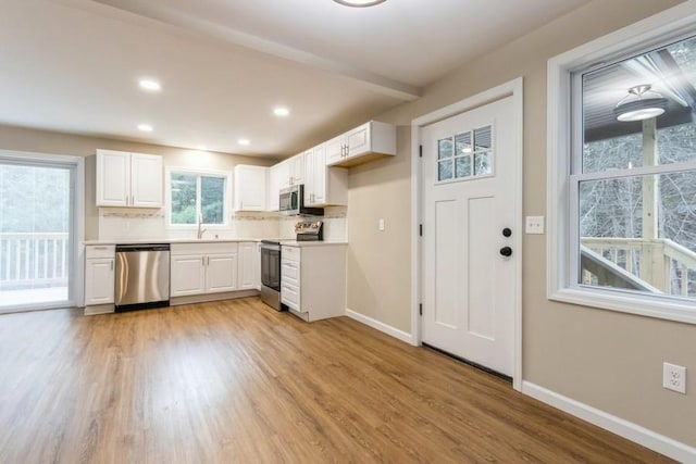 435 State Route 55, Eldred, NY 12732 - kitchen with baseboards, light wood-style flooring, stainless steel appliances, and white cabinetry