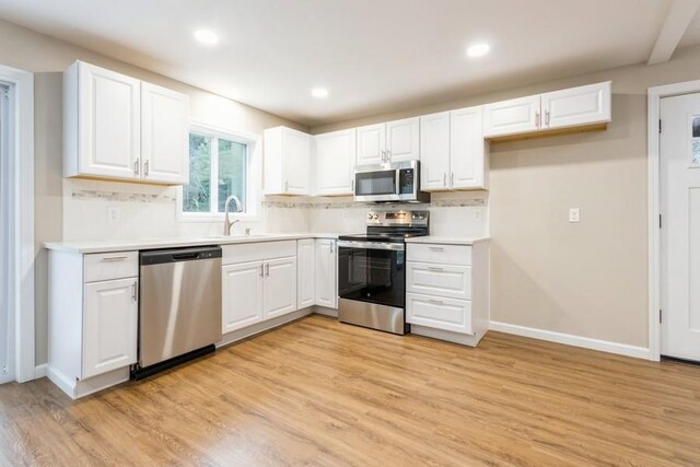 435 State Route 55, Eldred, NY 12732 - kitchen with decorative backsplash, stainless steel appliances, white cabinetry, and a sink