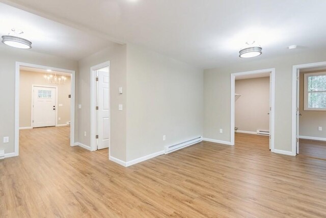 435 State Route 55, Eldred, NY 12732 - spare room featuring an inviting chandelier, baseboards, a baseboard heating unit, and light wood-style flooring