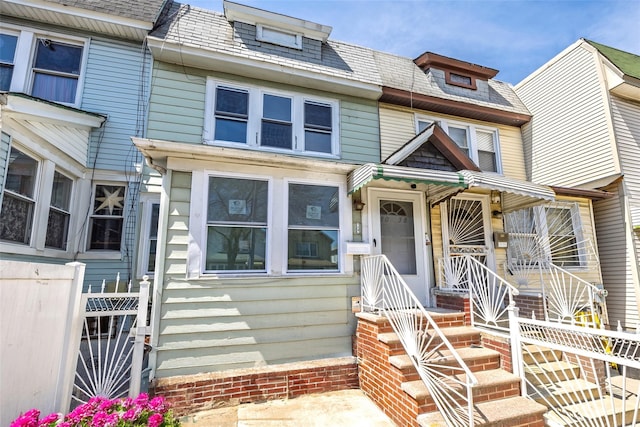 townhome / multi-family property with a high end roof and fence
