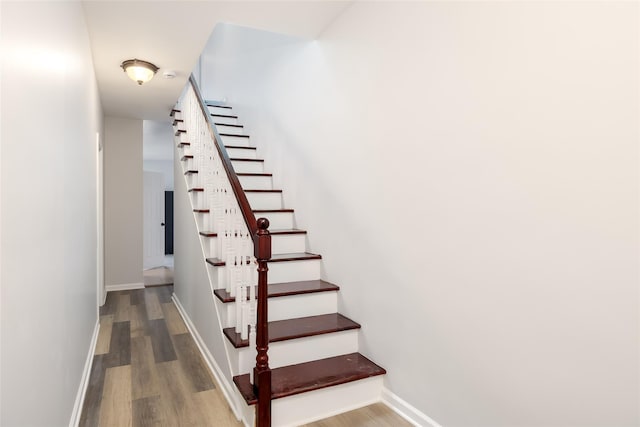 stairs with baseboards and wood finished floors