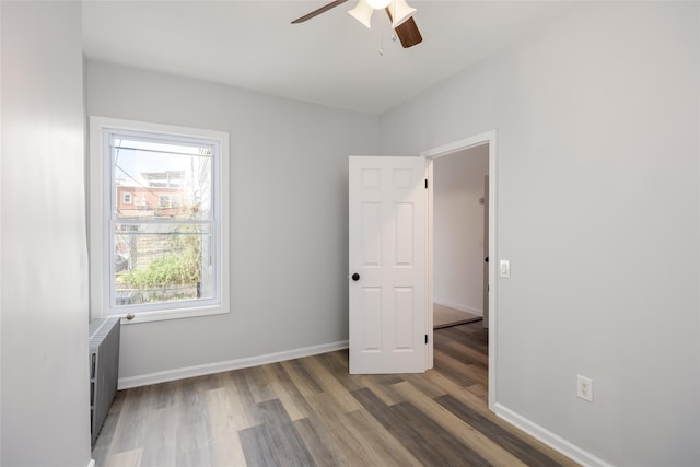 unfurnished bedroom featuring baseboards, ceiling fan, and wood finished floors