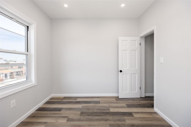 spare room with recessed lighting, baseboards, and wood finished floors