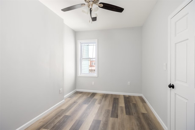 spare room with baseboards, ceiling fan, and wood finished floors