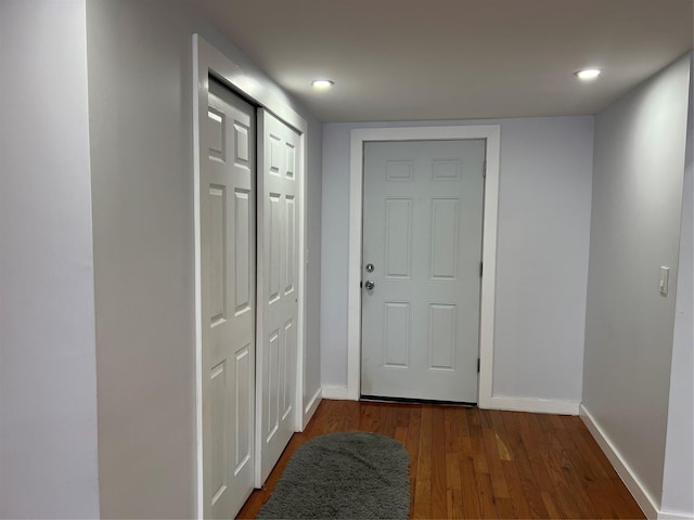 doorway to outside featuring baseboards and wood finished floors