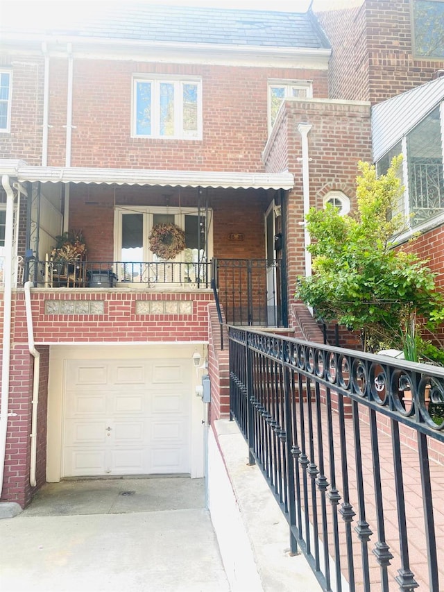 view of front of home with an attached garage, driveway, and brick siding