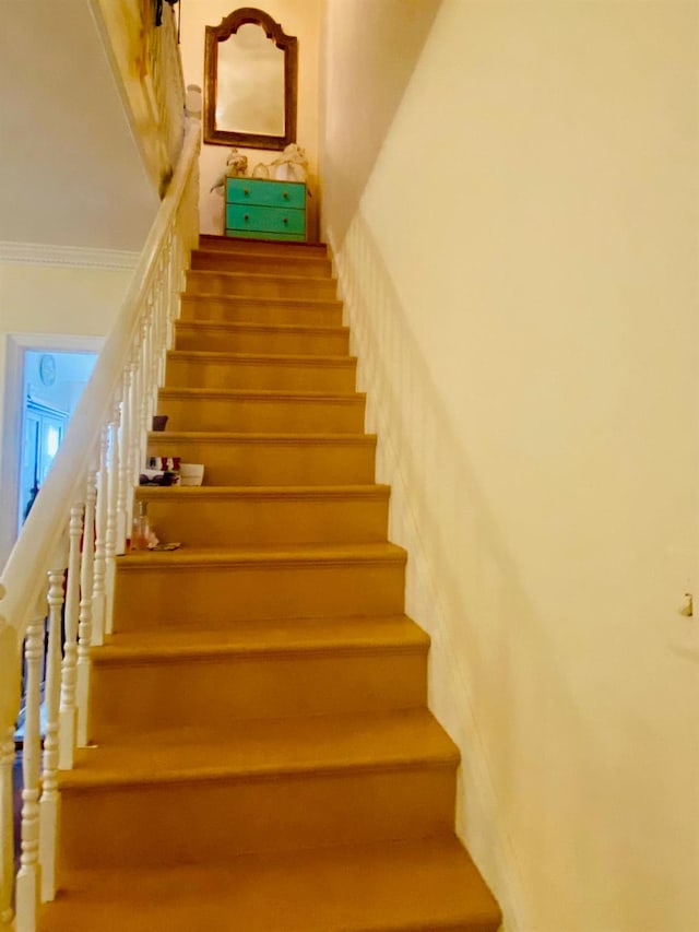 staircase featuring crown molding