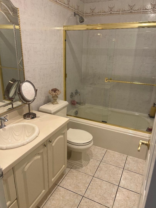 163-20 88th St, Howard Beach, NY 11414 - bathroom with vanity, toilet, tile patterned flooring, bath / shower combo with glass door, and tile walls