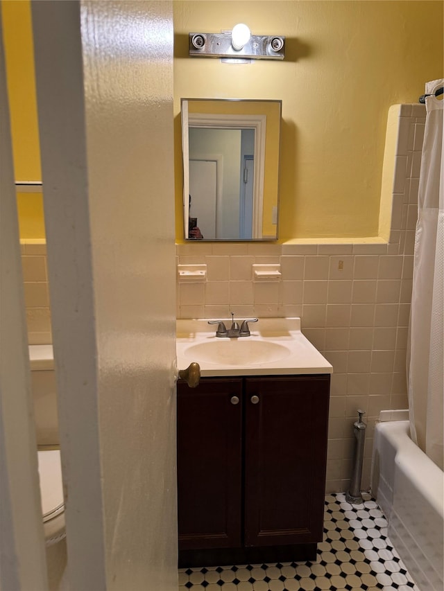 91 Tulip Ave Unit C2, Floral Park, NY 11001 - bathroom featuring vanity, tile patterned flooring, a wainscoted wall, and tile walls