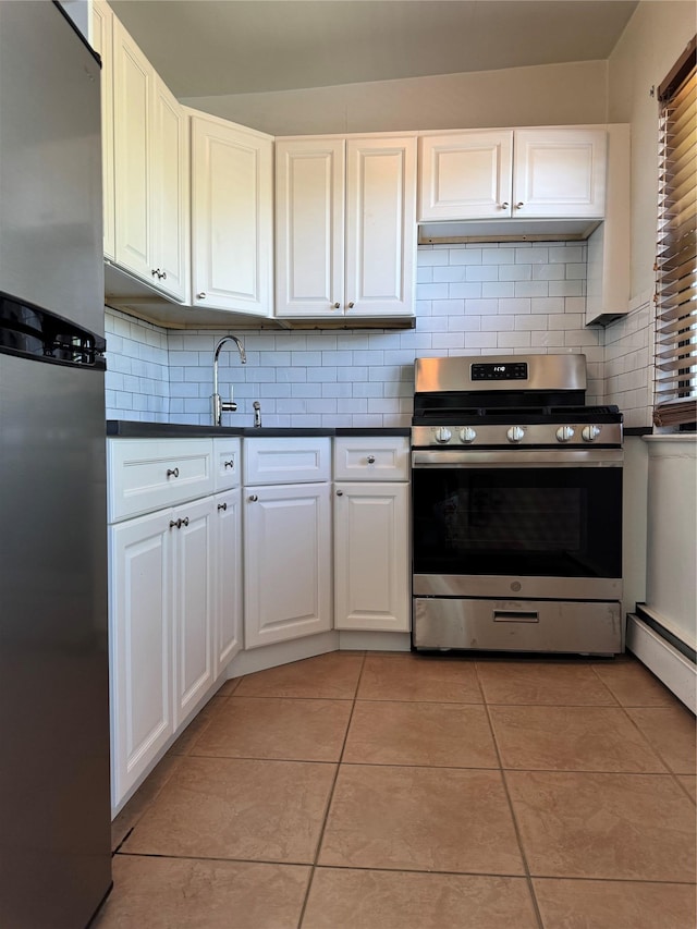 91 Tulip Ave Unit C2, Floral Park, NY 11001 - kitchen with dark countertops, tasteful backsplash, light tile patterned floors, white cabinets, and stainless steel appliances