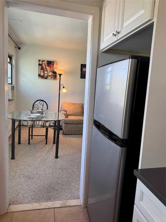 91 Tulip Ave Unit C2, Floral Park, NY 11001 - kitchen featuring freestanding refrigerator, white cabinets, dark countertops, and carpet