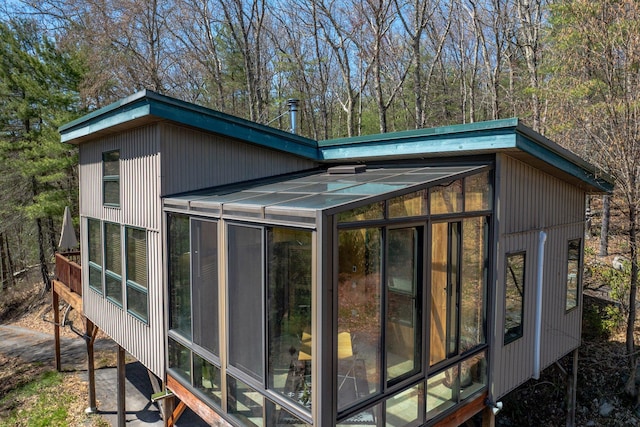 view of property exterior with a sunroom