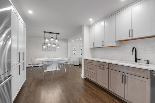 19 Morewood Oaks Prt, Washington, NY 11050 - kitchen featuring decorative backsplash, appliances with stainless steel finishes, hanging light fixtures, dark wood finished floors, and a sink